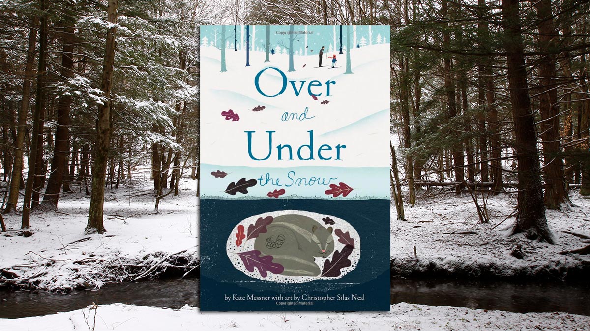 The cover of the book "Over and Under the Snow" on top of a snowy winter forest